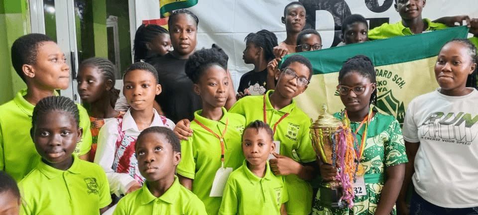The winning school team with their trophy and school colours